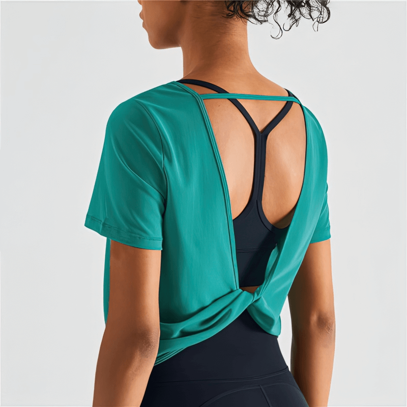 Stylish quick-drying women's sports T-shirt with open back design in teal. Ideal for workouts. Breathable nylon material.