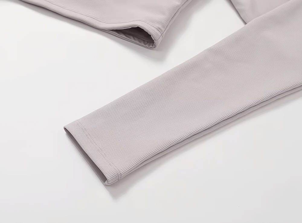 Close-up of a stylish ribbed yoga top sleeve in beige, designed for women’s fitness and outdoor activities.