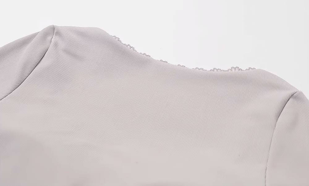 Close-up view of a stylish ribbed long-sleeve yoga top in light gray, perfect for running and fitness with quick-dry and stretchy fabric.