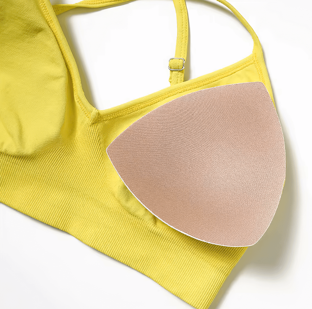 Yellow seamless yoga bra with criss-cross straps and removable padding for high support in fitness and active wear.