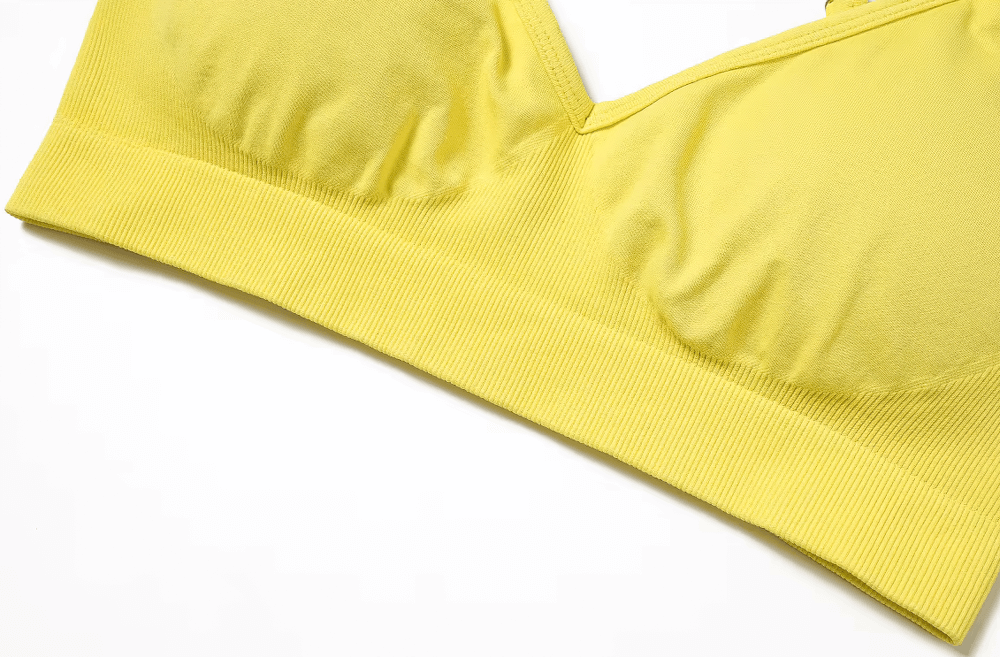 Seamless yellow yoga bra with criss-cross straps, high support, push-up design, made from breathable and quick-dry nylon and spandex.