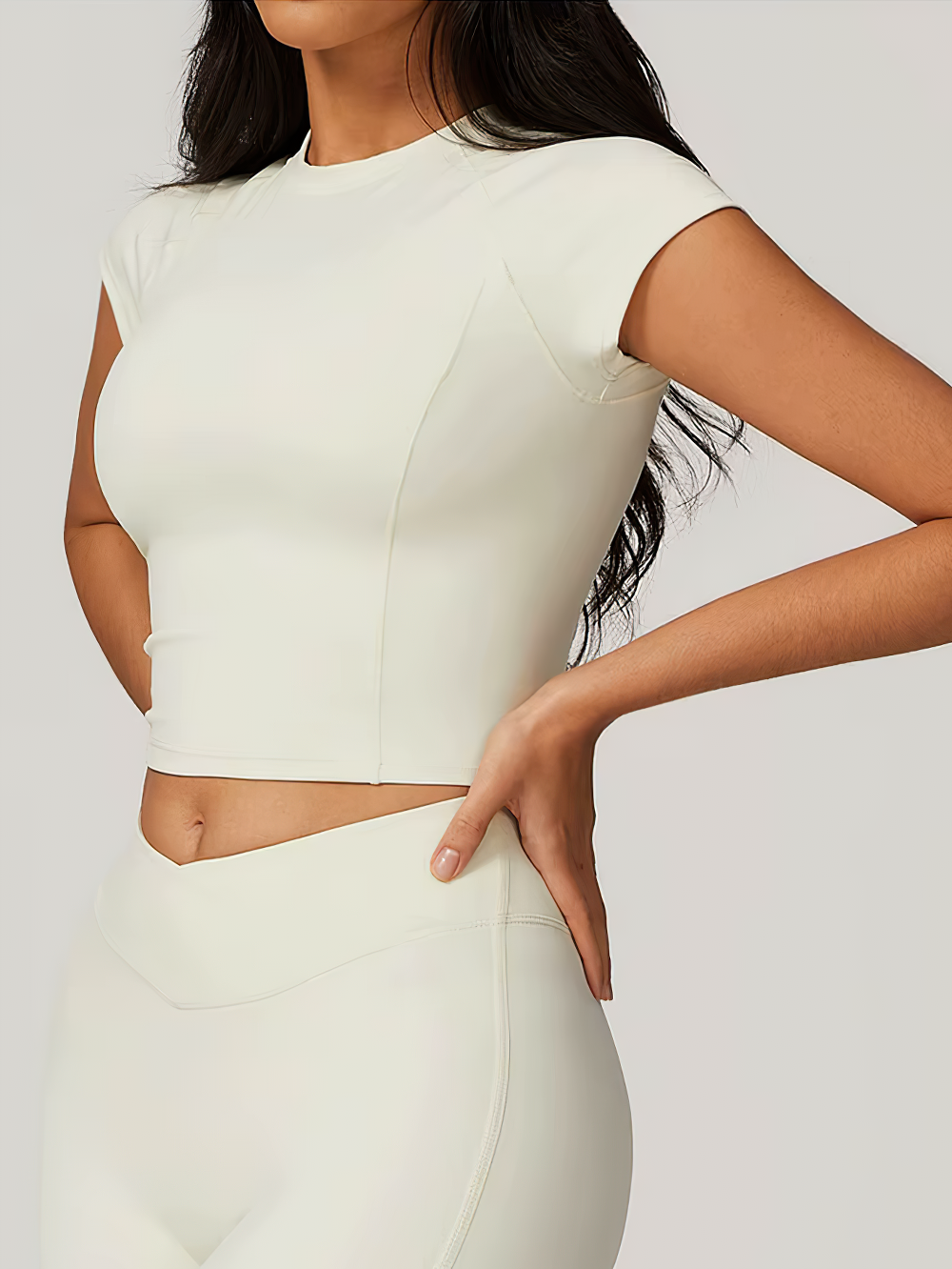 Stylish short-sleeve crop yoga top for women in cream. Ideal for fitness, hiking, and dancing with breathable nylon-spandex fabric.