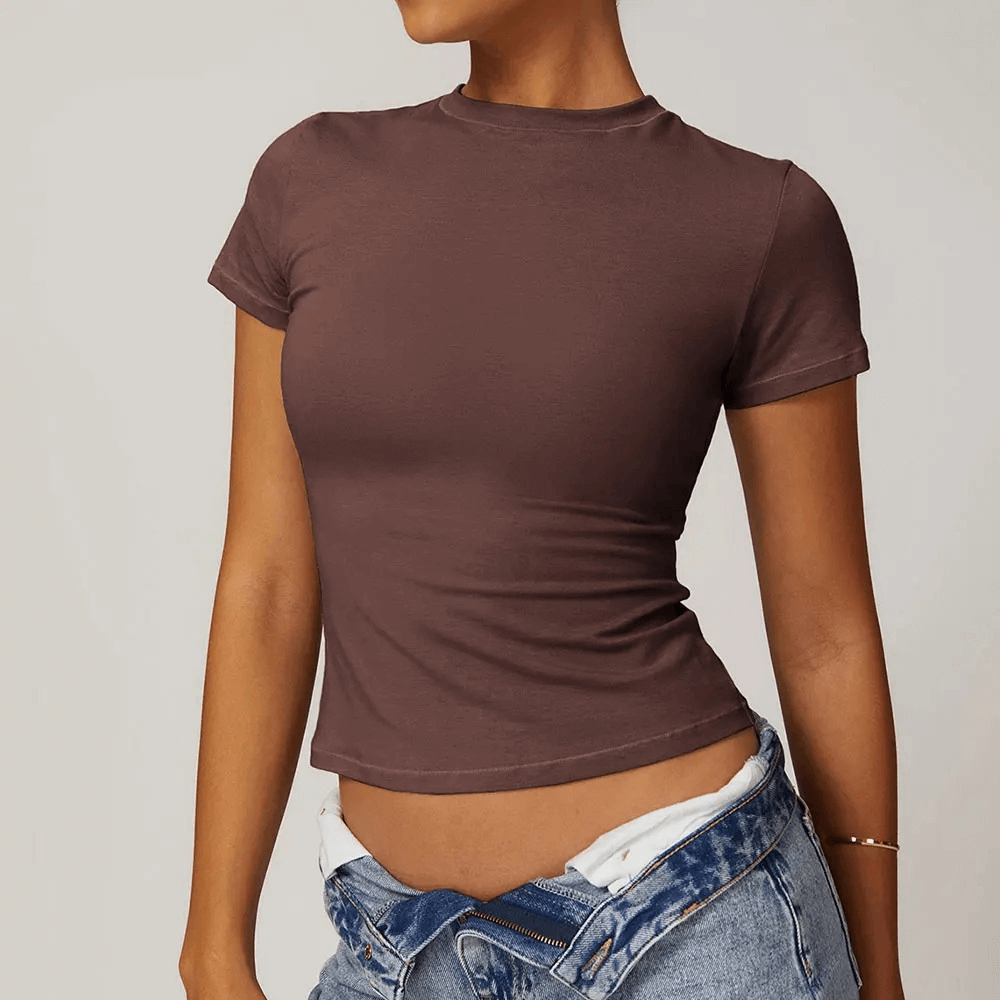 Woman wearing a brown short-sleeve yoga t-shirt with jeans, perfect for fitness and casual style. Made of cotton and spandex for flexibility.