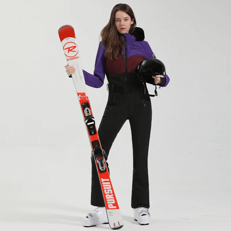 Woman in Stylish Snowboarding Suit SF2069 with thermal insulation, holding skis and helmet, ready for the slopes. Snow Ready Performance Gear.