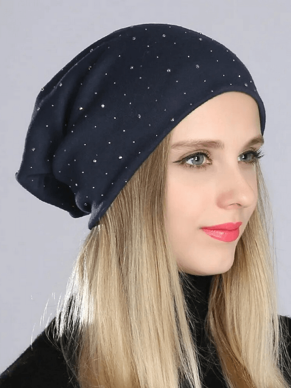 Woman wearing stylish solid color beanie with rhinestones, adding sparkle to her casual look. Made from lightweight polyester. SF1689