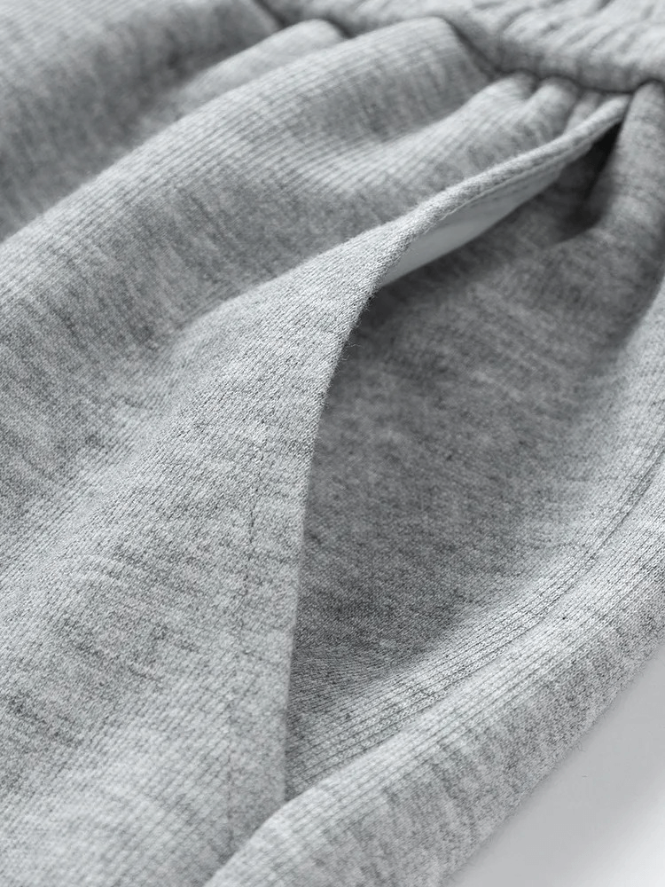 Close-up of grey sporty men's pants with a focus on the pocket details, showcasing stylish design and durable material.