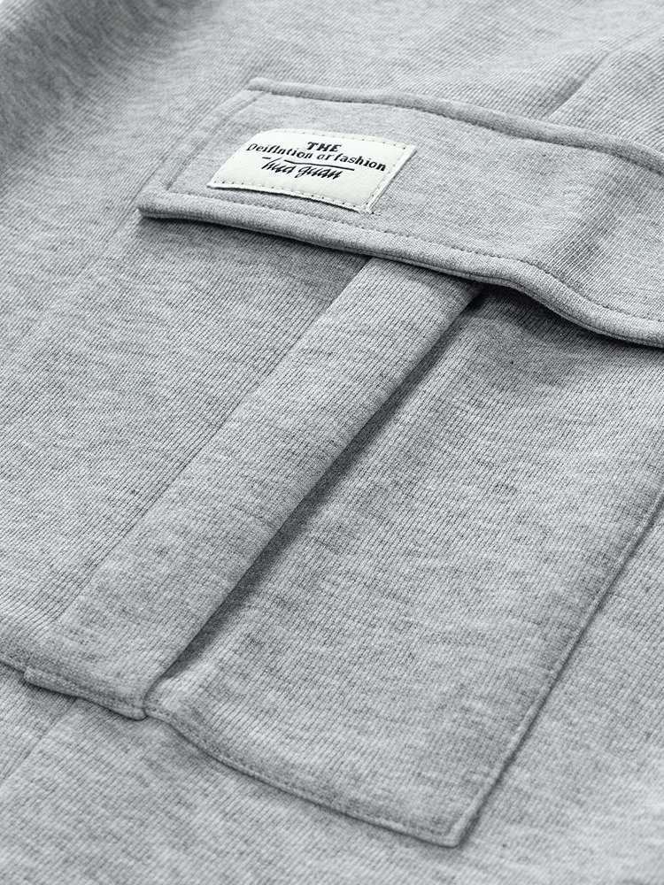 Close-up of grey sports pants with pockets, featuring a stylish design and a comfy cotton-polyester blend. Perfect for active men.