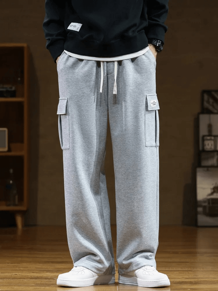 Gray stylish sports men's pants with several pockets, midrise waist, loose fit, and drawstring closure. SF1977 model on display.