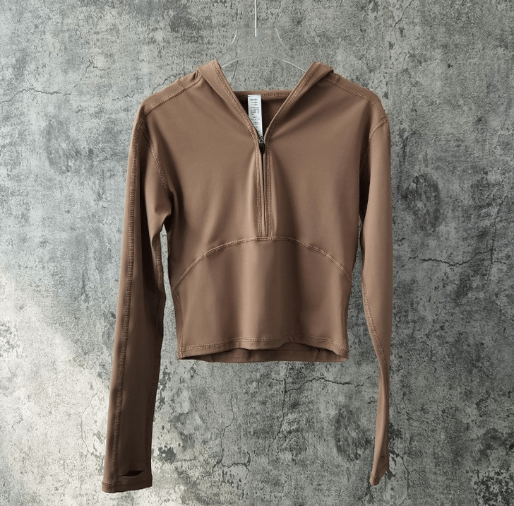 Stylish women's sports top with long sleeves and hood, perfect for yoga; made of breathable, quick-dry nylon and spandex. SF1430