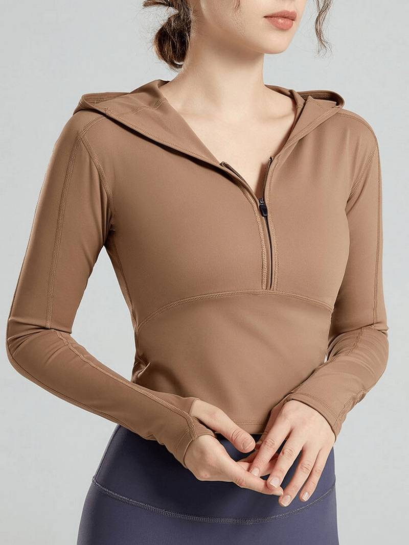 Stylish women's sports top with long sleeves and hood, ideal for yoga. Made of breathable, quick-dry nylon and spandex fabric.