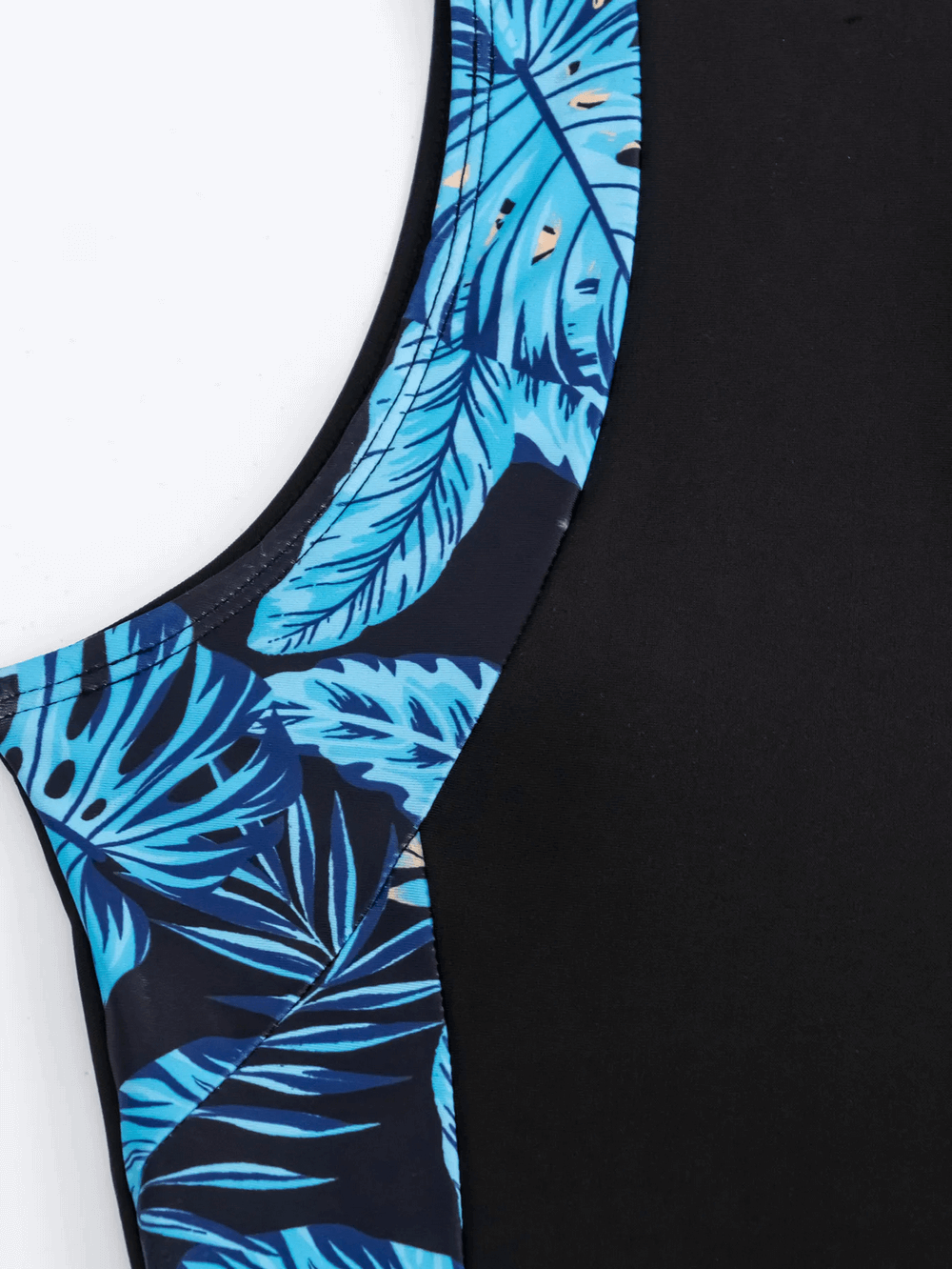 Close-up of stylish tropical print zip-up swimsuit for women showcasing vibrant blue leaf pattern on side panel.