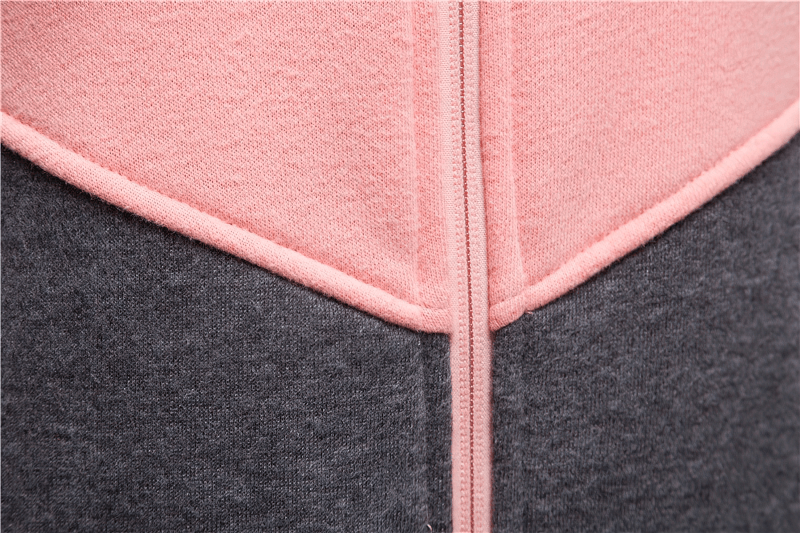 Close-up of a stylish two-tone zip hoodie, showcasing color block patchwork in pink and gray for a sporty chic look.