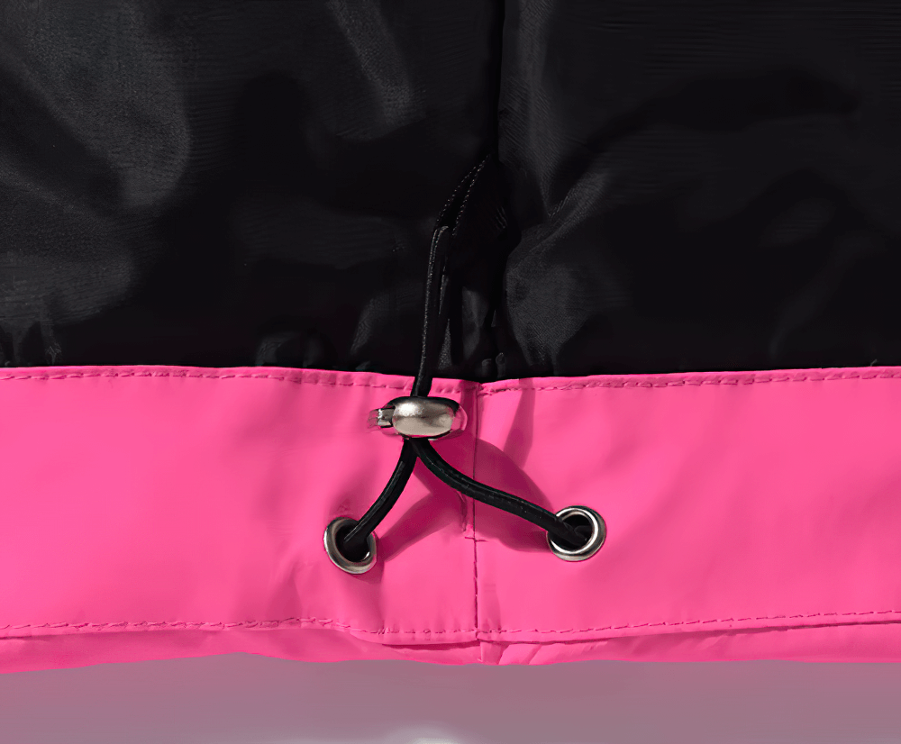 Close-up of a stylish unisex ski jacket with an adjustable pink hem and black waterproof fabric, designed for winter sports.