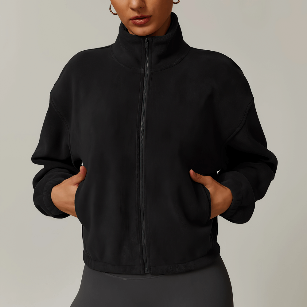 Woman in black anti-pilling fleece jacket with zipper and pockets, perfect for outdoor activities like running and hiking.