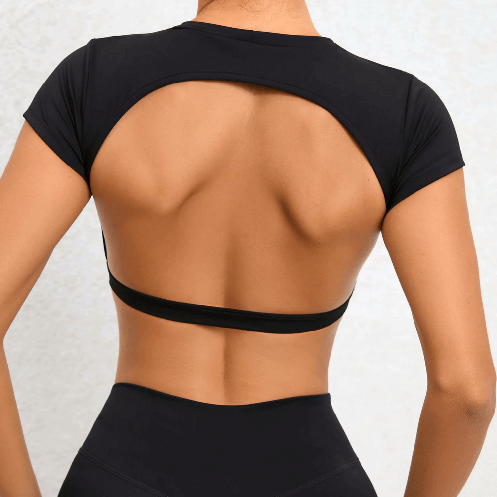 Back view of a stylish black backless yoga crop top with short sleeves, perfect for yoga and fitness activities, made of nylon and spandex.