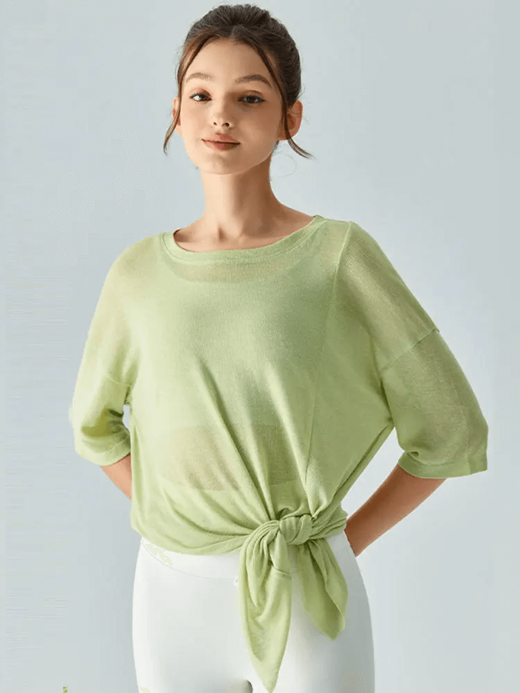 Young woman wearing a green stylish loose-fit short sleeve t-shirt with a front tie, perfect for casual outings and layering.