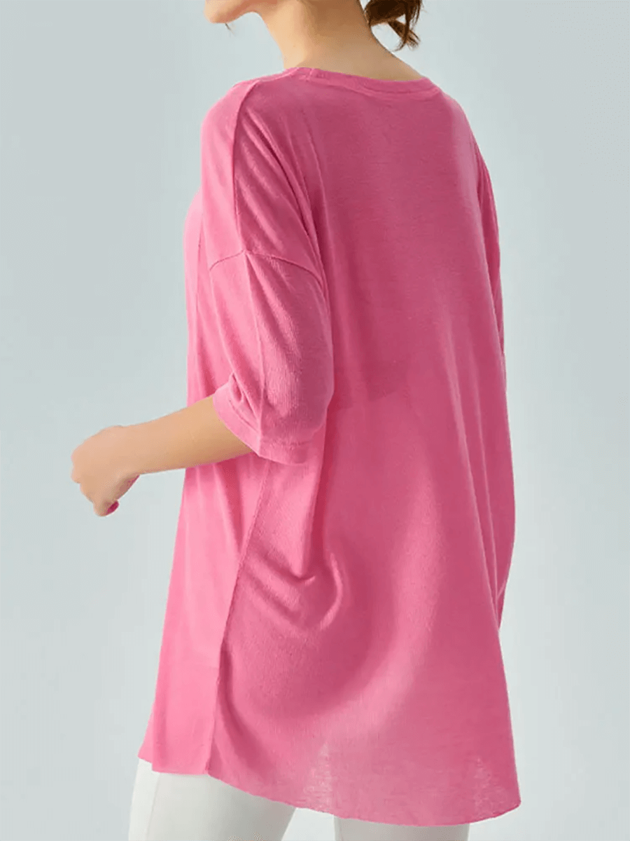 Woman wearing a stylish pink loose-fit short-sleeve t-shirt, showcasing its lightweight fabric and relaxed drape for casual outfits.