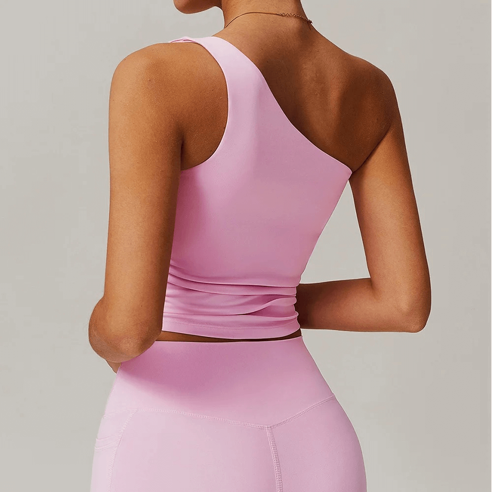 Woman wearing a Stylish Women's One-Shoulder Fitness Tank Top in pink showcasing elegance and flexibility, perfect for fitness activities.