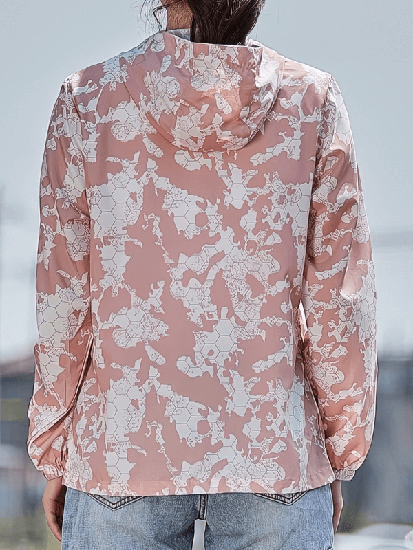 Back view of a floral-patterned pink waterproof windbreaker jacket with a hood, worn by a woman, perfect for outdoor activities.