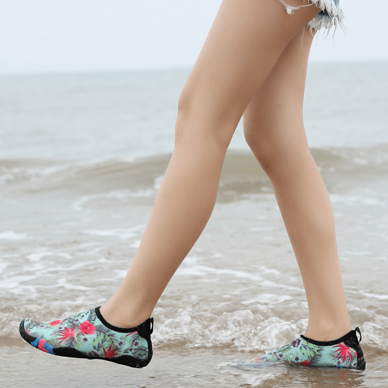 Walking on the beach wearing Swimming Printed Non-Slip Quick Dry Unisex Beach Footwear, showcasing floral design and slip resistance.