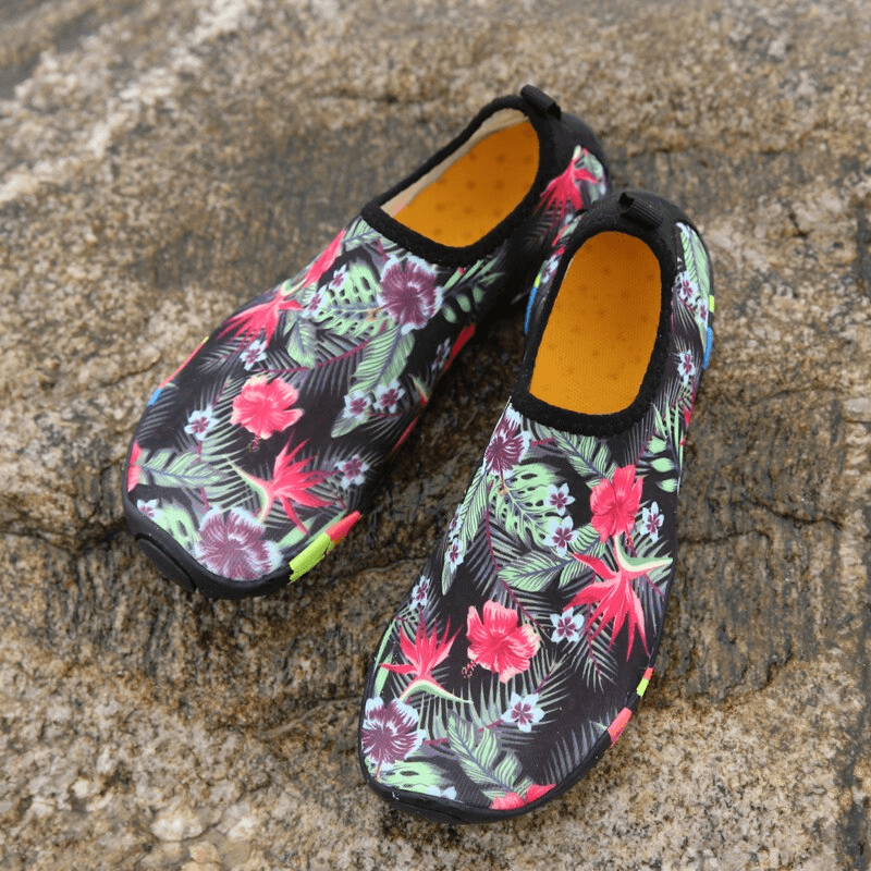 Tropical print quick-dry non-slip beach shoes, unisex design, on textured stone background.