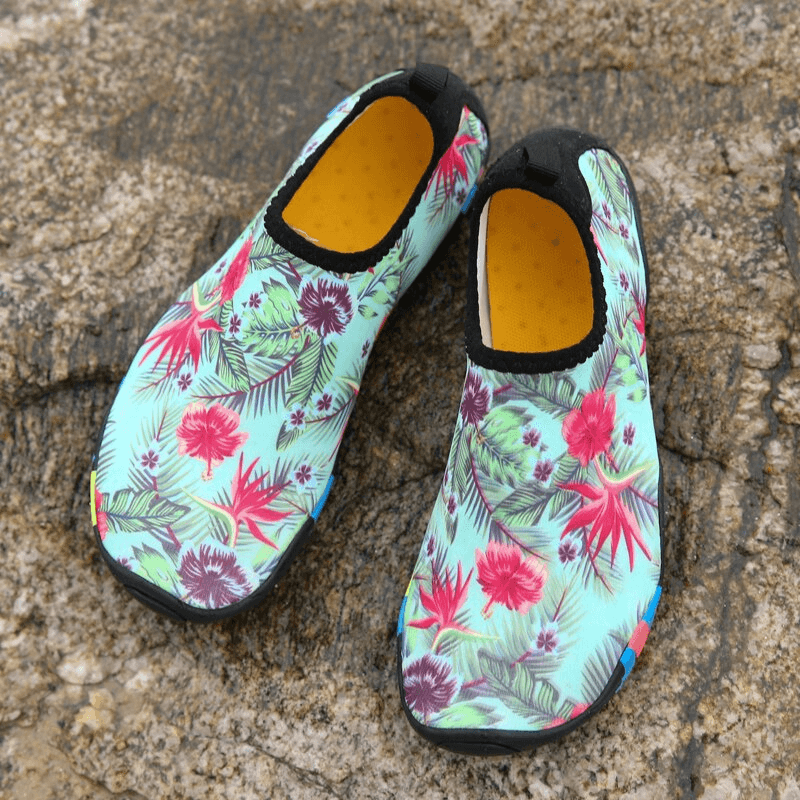 Floral printed quick-dry unisex beach shoes on sand, featuring non-slip rubber soles for safe beach fun. Perfect for summer style.