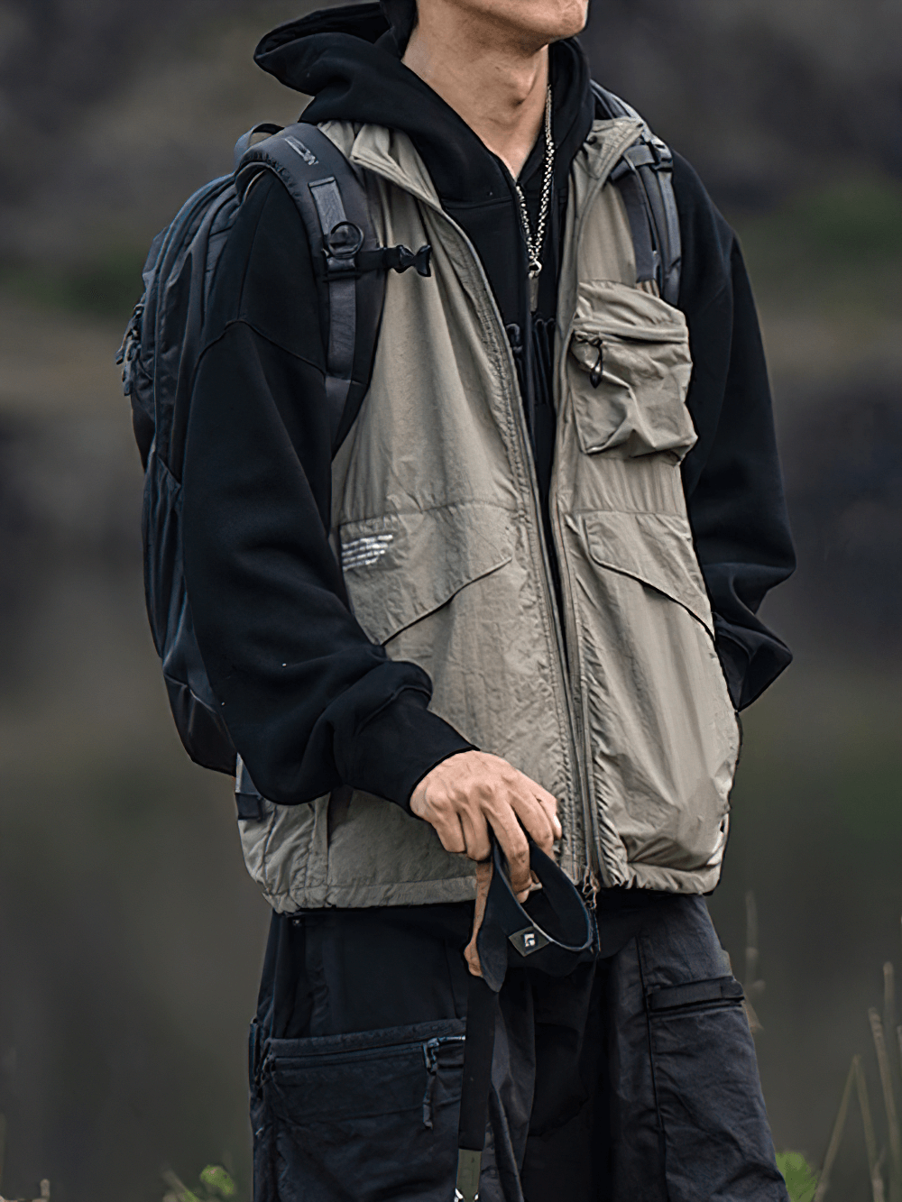 Man wearing Tactical Utility Vest SF2276 with backpack, showcasing outdoor multi-pocket design for hiking and streetwear.