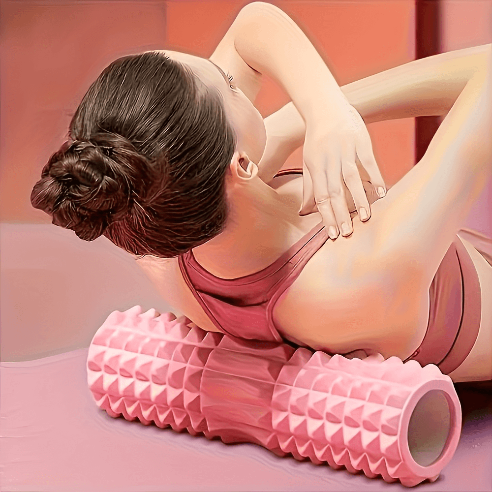 Woman using pink textured foam roller for deep tissue massage and muscle relaxation during yoga and Pilates routine.