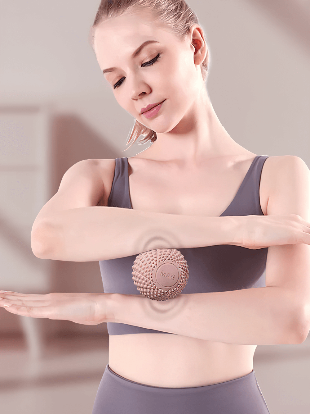 Woman using textured lacrosse massage ball for arm muscle relief and myofascial release therapy.