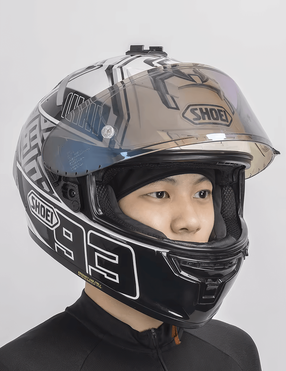 Person wearing a Shoei motorcycle helmet with a sleek design and tinted visor for enhanced protection and style.