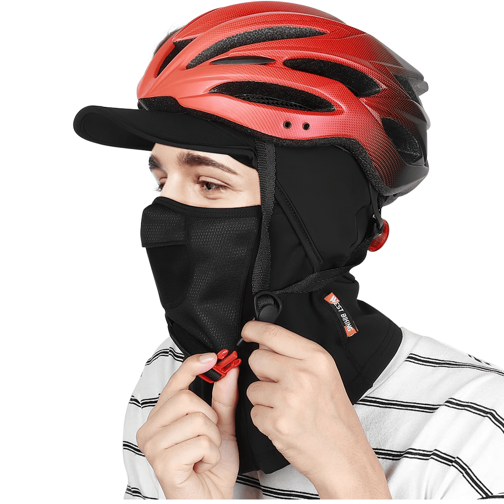 Cyclist adjusting thermal cycling cap with full face and neck coverage, wearing a red helmet; perfect for winter sports.