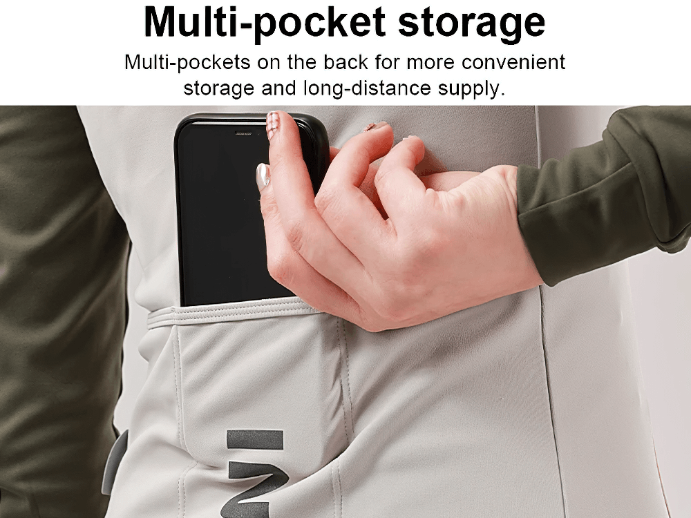 Woman placing phone in pocket of thermal cycling jacket with multi-pocket storage.