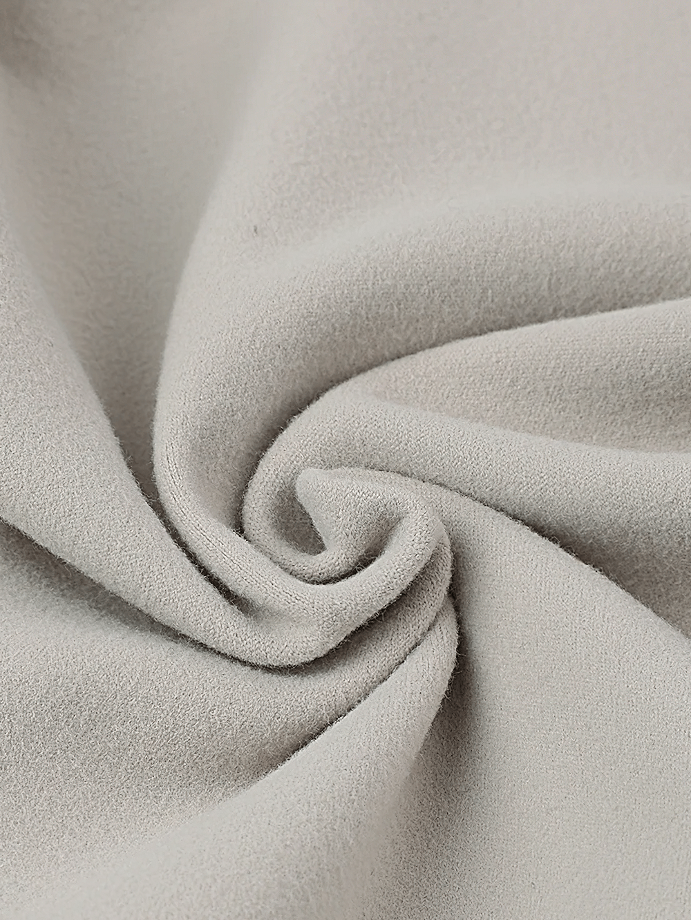 Close-up of soft grey fleece fabric used in women's cycling jackets, showcasing texture and warmth for outdoor adventures.