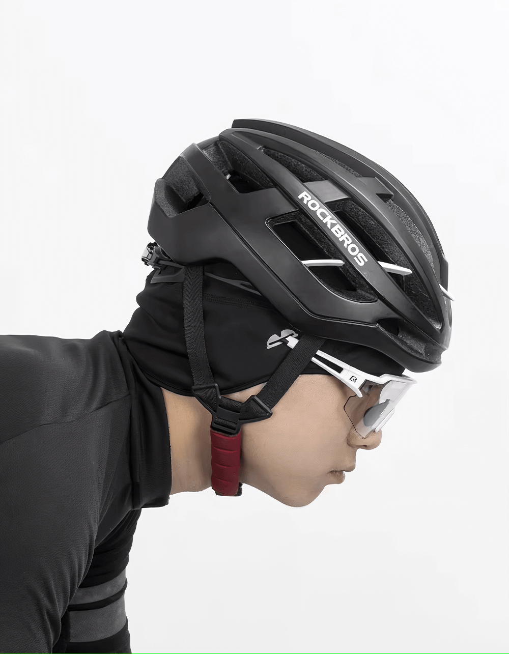 Profile of cyclist wearing a helmet and windproof cycling beanie, demonstrating sleek design and snug fit for winter conditions.