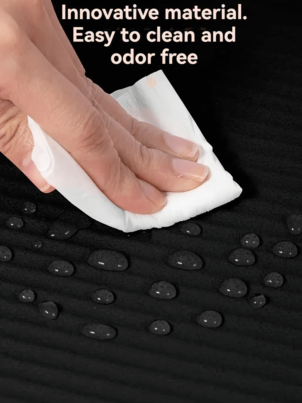 Hand wiping water droplets off a black NBR exercise mat, showcasing its easy-to-clean surface and odor-free quality.