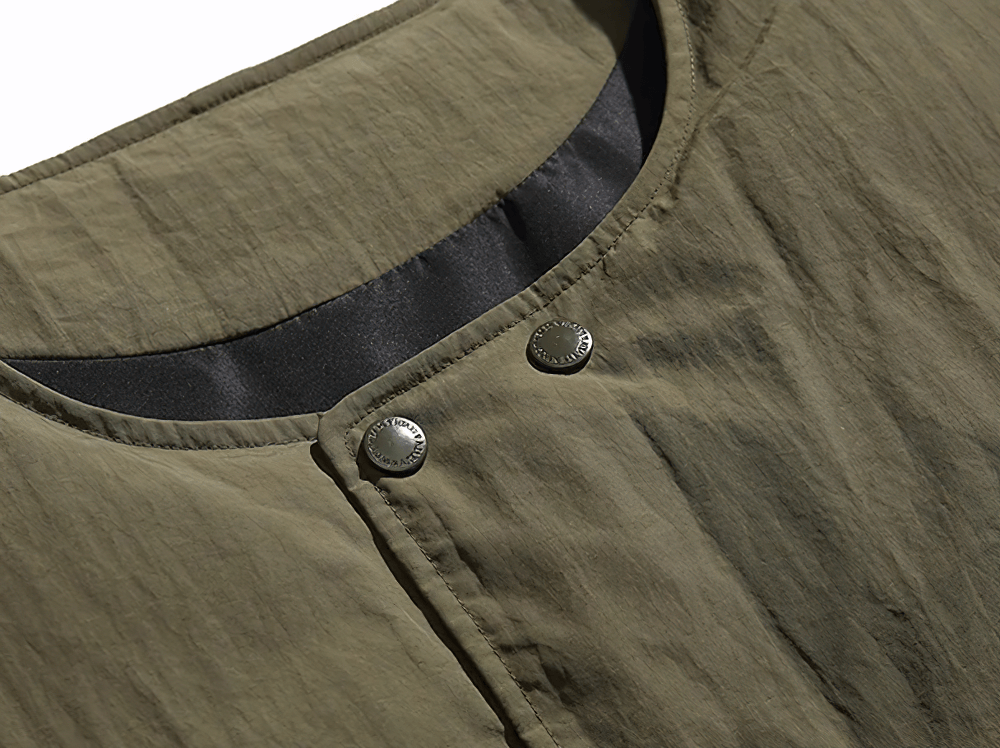 Close-up of olive nylon duck down vest with button closure, showcasing functional pocket design and durable fabric for outdoor adventures.