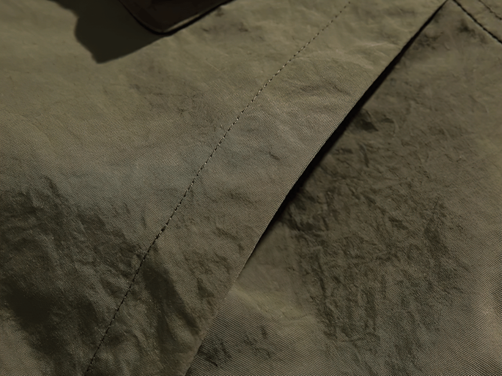 Close-up of nylon fabric on sleeveless duck down vest, showing durable material and craftsmanship.