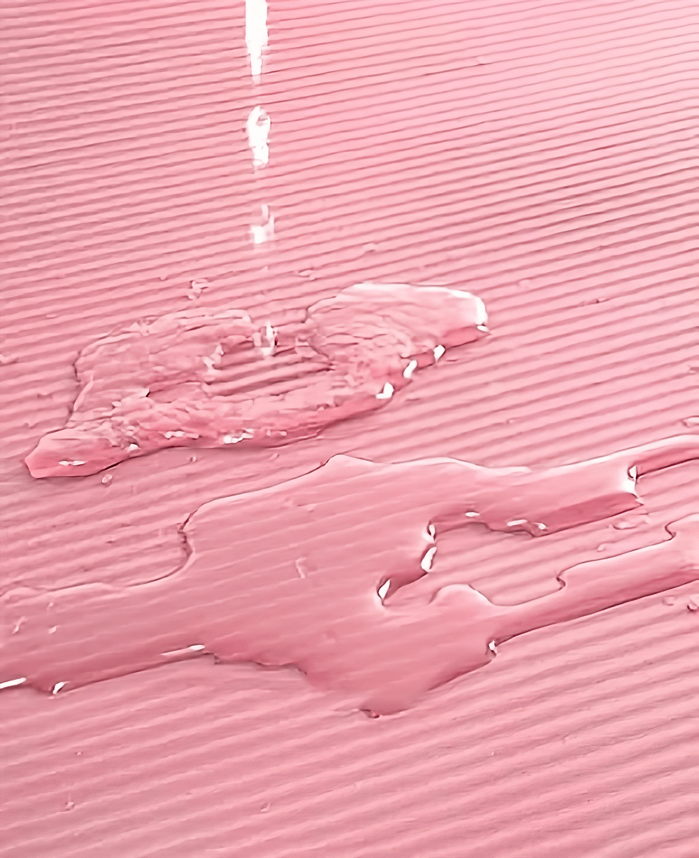 Close-up of pink non-slip yoga mat with water resistance feature, perfect for home and gym exercises like Pilates and fitness routines.