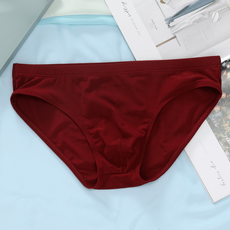 Red thin breathable ribbed briefs for men with low-rise waist, casual underwear style, displayed on a colorful background for product showcase.