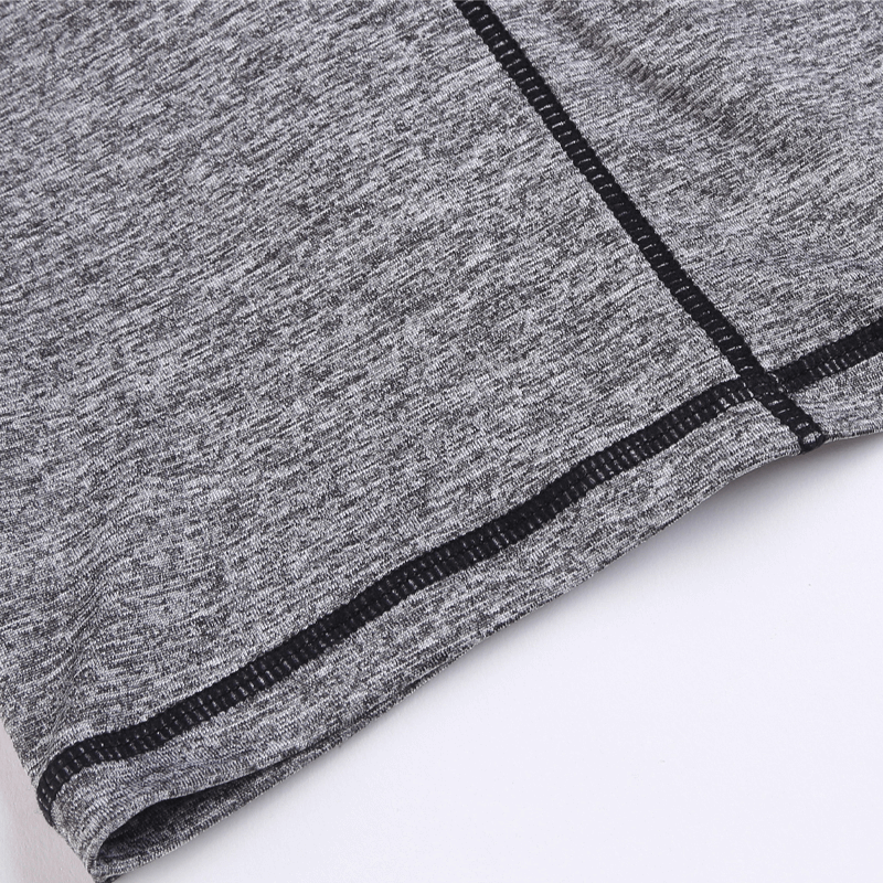 Close-up of gray thin breathable workout shorts featuring quick-dry polyester fabric and patchwork design.