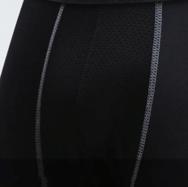 Close-up of black men's compression running leggings with breathable fabric and detailed stitching, perfect for sports and workouts.