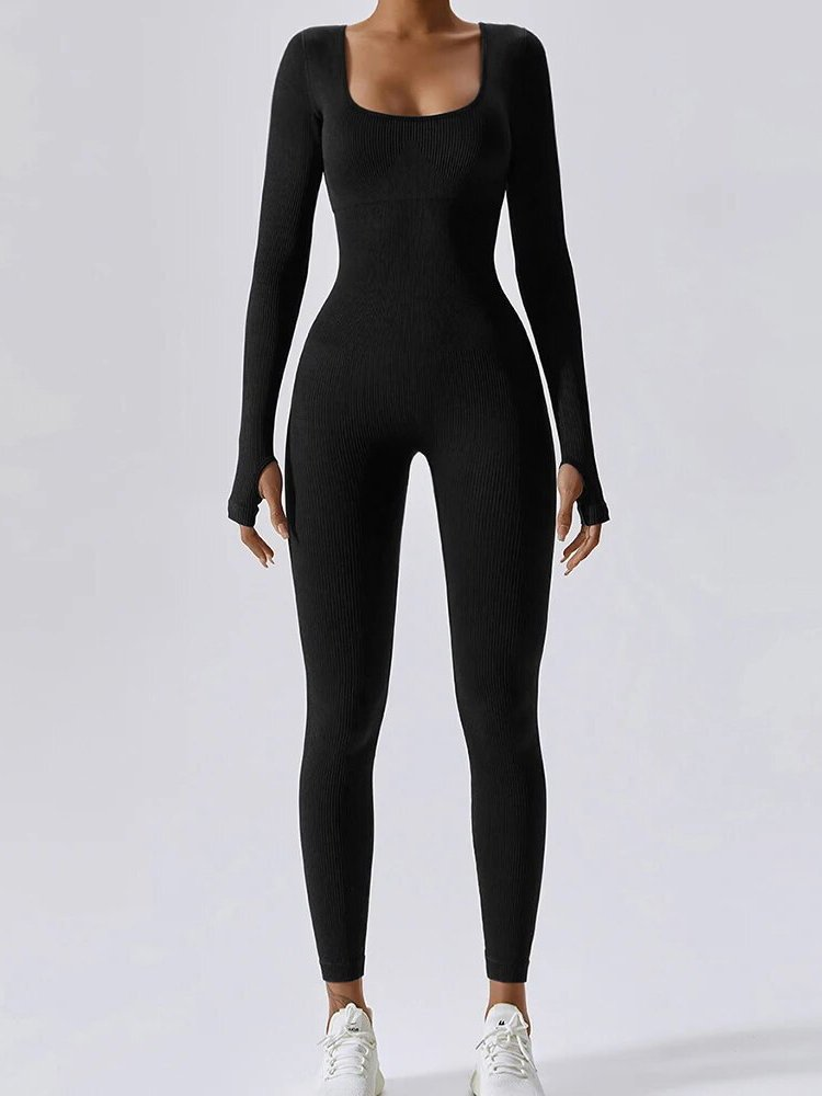 Woman wearing a black tight elastic one-piece sports jumpsuit with full sleeves, ideal for yoga and workouts.