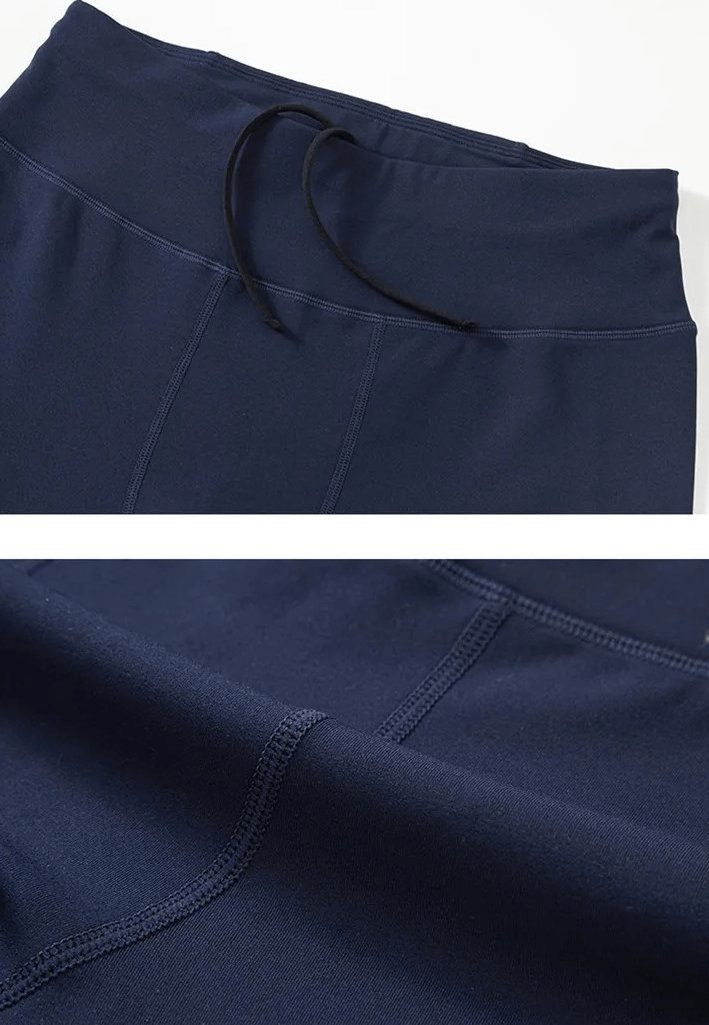 Close-up of navy blue men's leggings with drawstring and stitching detail, featuring back pocket for sports and running.