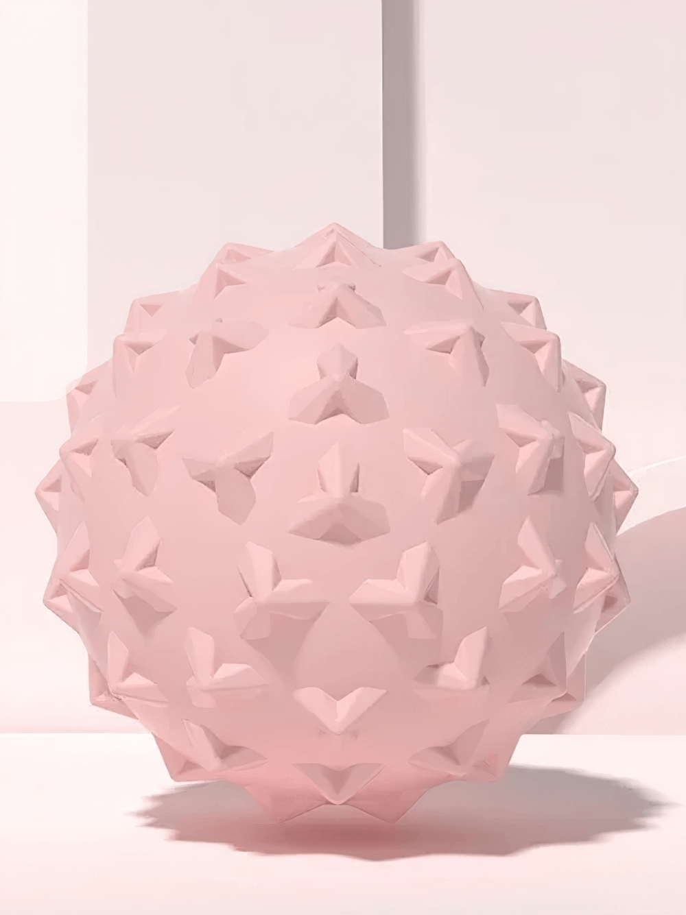 Pink TPE mini yoga massage ball with textured surface for muscle relaxation and trigger point relief.
