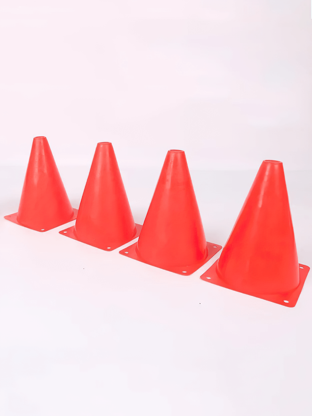 Four red training cones aligned for sports drills, made of durable PVC for agility and coordination, perfect for soccer training.