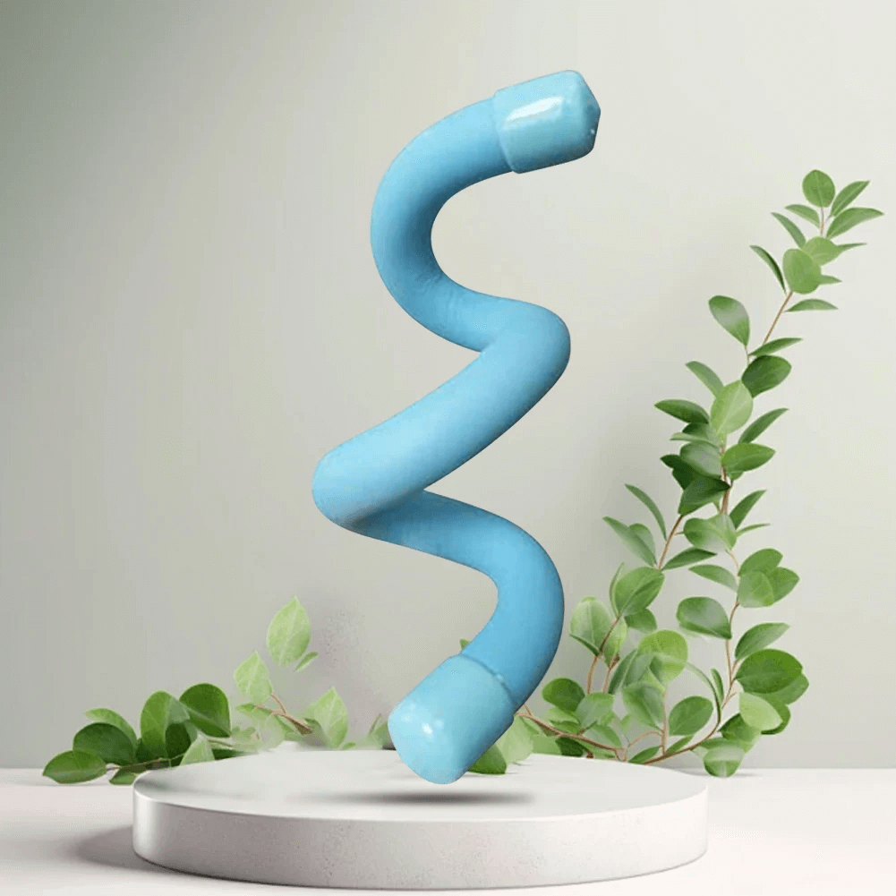 Curved blue abstract sculpture on white pedestal with green leaves in background, minimalist modern decor