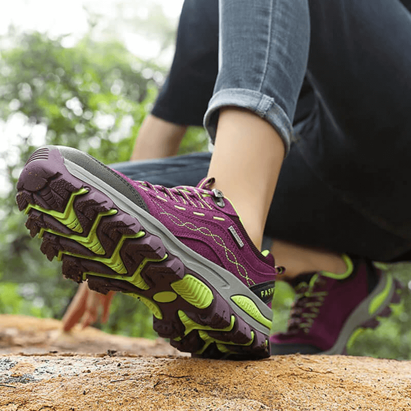 Woman wearing Trekking Women's Sneakers SF0232 with lace-up design, purple color, hiking on a trail showcasing shoe grip and comfort.
