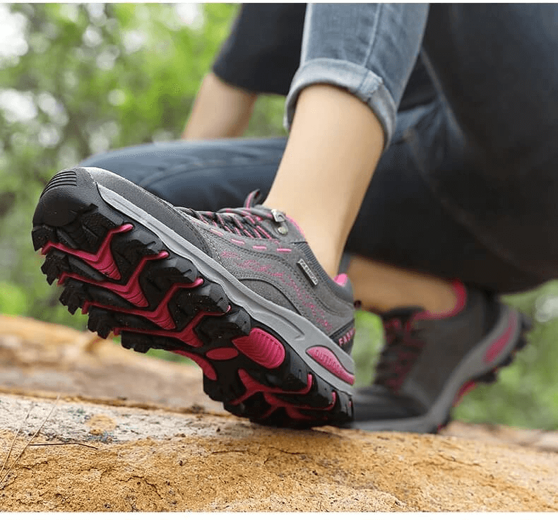 Woman wearing Trekking Women's Sneakers SF0232 with lace-up design on rugged terrain, highlighting grip and durability.