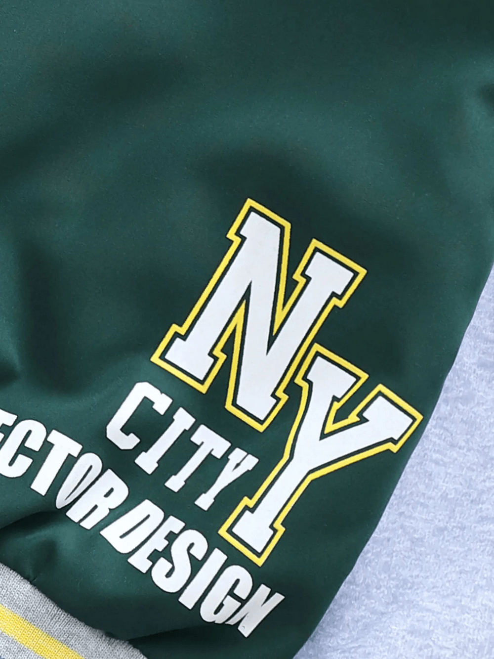 Close-up of trendy unhooded color-blocked baseball jacket with bold NY letter print, perfect for kids' sporty casual outfits.