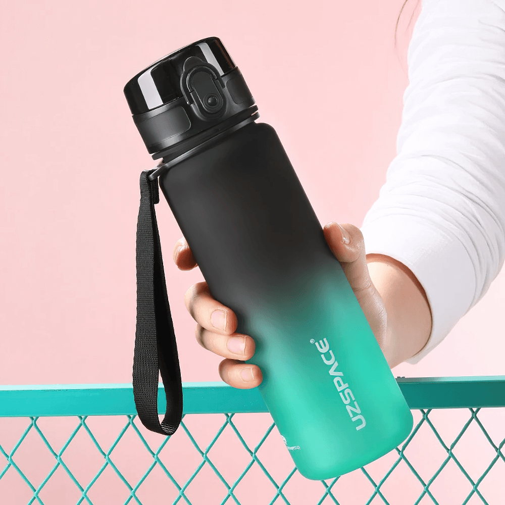 Tritan sports water bottle with timeline, leakproof and BPA-free, held by a hand. Ideal for outdoor fitness, 500ml capacity.